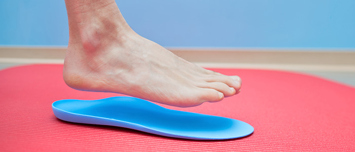 A foot stepping onto a custom orthotic